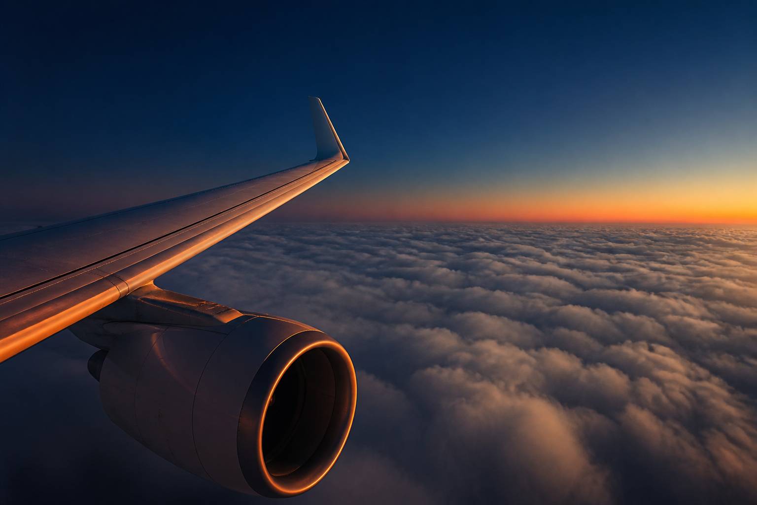 Aile d'avion avec réacteur sous une lumière ambrée
